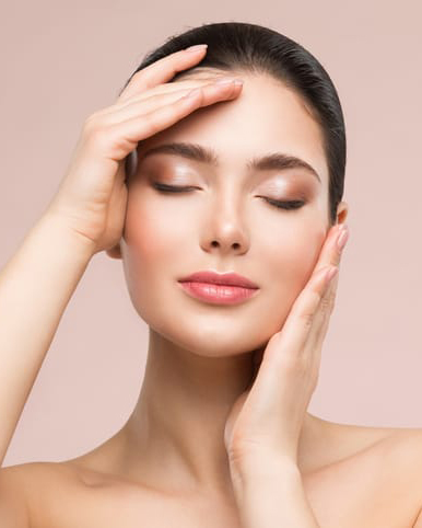 Beautiful Woman Face Skin Care. Natural Make up. Skin Health Treatment. Model massaging Face by Hands. Beige background